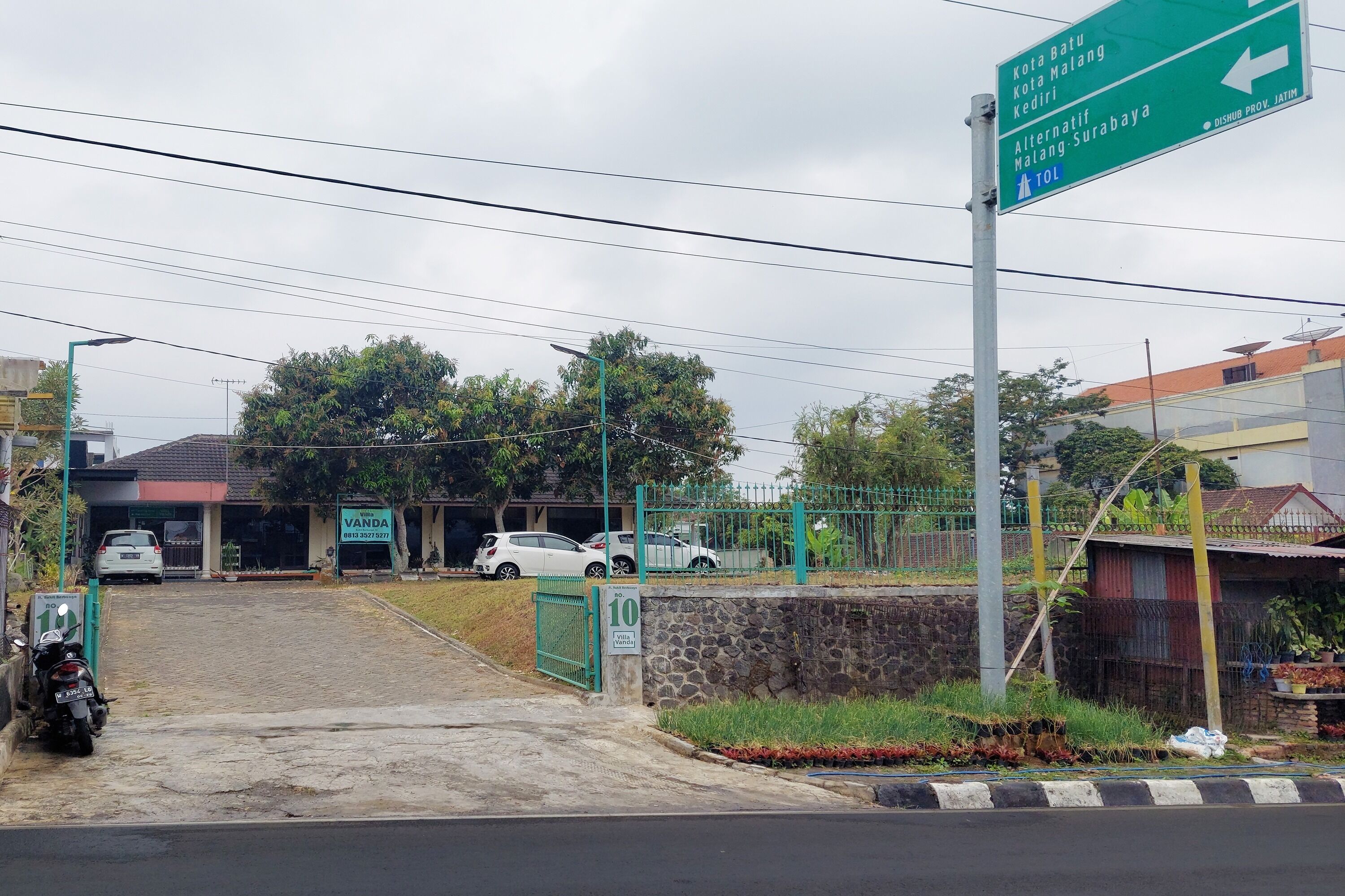 A road sign with directions to Kota Batu, Kota Malang, Kediri, and an alternative route to Malang-Surabaya.