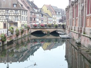 Ein Kanal mit Gebäuden an beiden Seiten, einer Brücke und einer schwimmenden Ente.