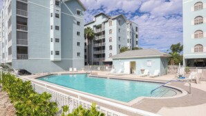 A multi-story building with a swimming pool and outdoor seating area.