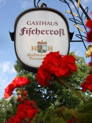 A sign for "GASTHAUS Ficheroff" with a crest and the words "Hofbräu Trau".