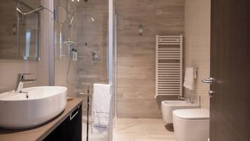 A modern bathroom with a large sink, a glass shower enclosure, and a toilet.