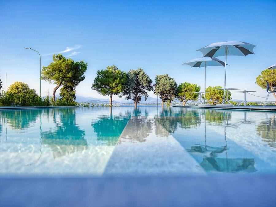 Alberca al aire libre, sombrillas en la alberca y camastros