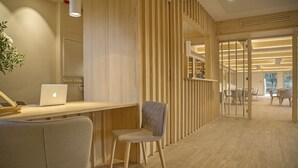 A modern office space with a wooden desk, a laptop, and a chair.