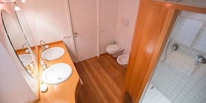Un baño con dos lavamanos, un inodoro y una ducha.