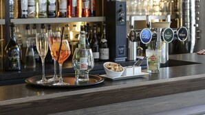 A bar area with a variety of liquor bottles, glasses, and a cocktail machine. - Hôtel Restaurant Novalaise Plage (Novalaise)