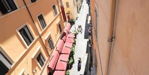 A narrow street with buildings on either side, featuring balconies and windows. - Spanish Step Suite (Rome)
