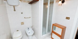 A bathroom with a toilet, bidet, and shower area. - Spanish Step Suite (Rome)