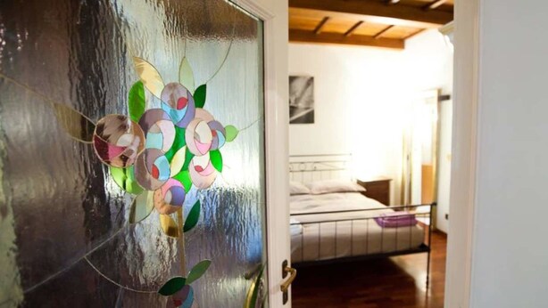 Une chambre à coucher avec un lit, une table de chevet et une étagère fixée au mur.