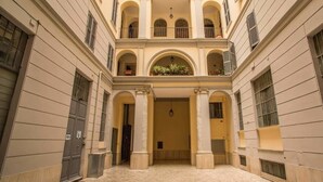 Un edificio con patio central, columnas y balcones.