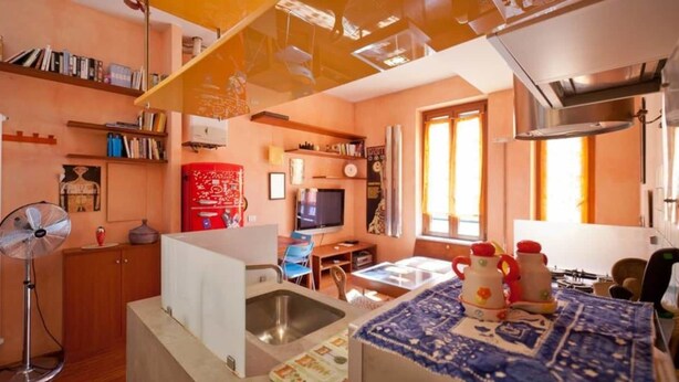 Kompakti asuintila, jossa on pieni keittiö, ruokailutila ja televisio.