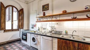 A compact kitchen with a washing machine, a stove, and a sink. - Campo de Fiori 3 bedroom apartment (Rome)