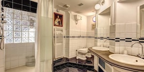 Un bagno con due lavandini, una doccia e un water.