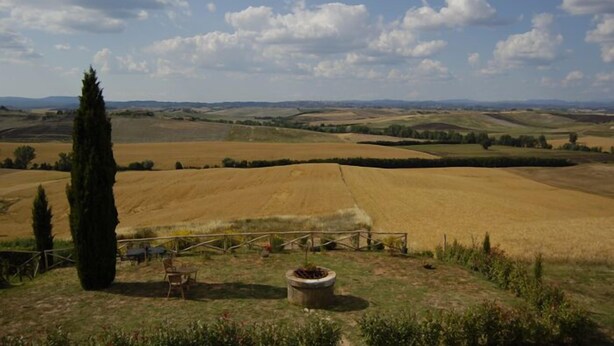 Un paysage rural avec des champs vallonnés et un ciel dégagé.