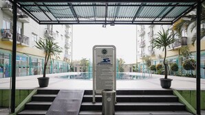 Un acceso cubierto a un edificio residencial con un letrero que indica que es The Suites @ Metro Apartment.