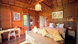 Una habitación tipo cabaña de madera con una cama, un escritorio y una silla.