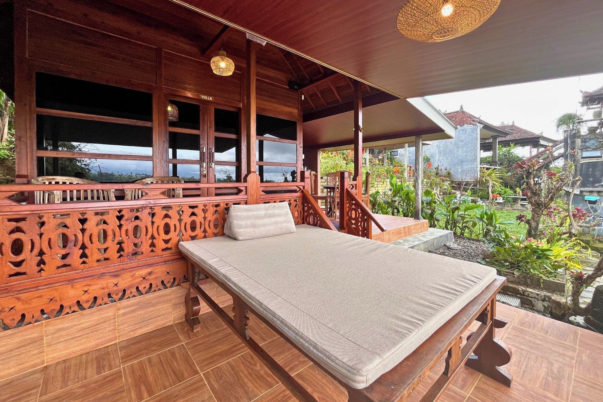 Una habitación de madera con una cama, vistas al jardín y una escalera.