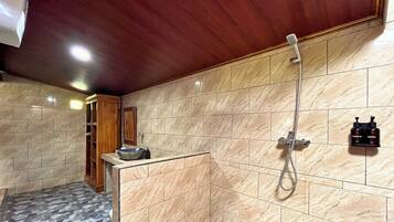 A bathroom with a shower, a sink, and a mirror.