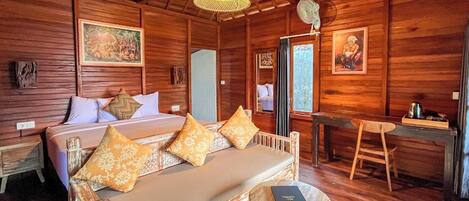 Una habitación de madera con cama, sofá, escritorio y silla.