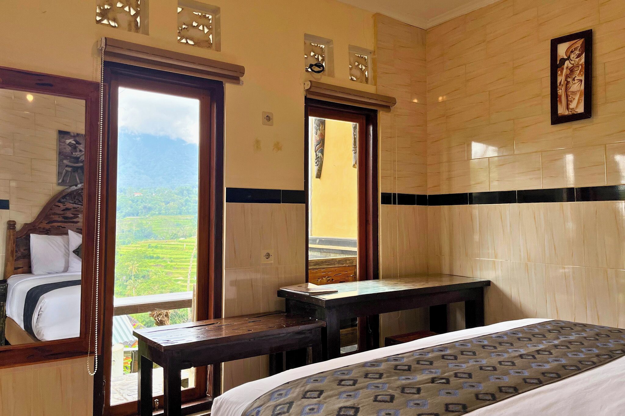 Habitació d'hotel amb llit, escriptori i vista a un paisatge muntanyós.