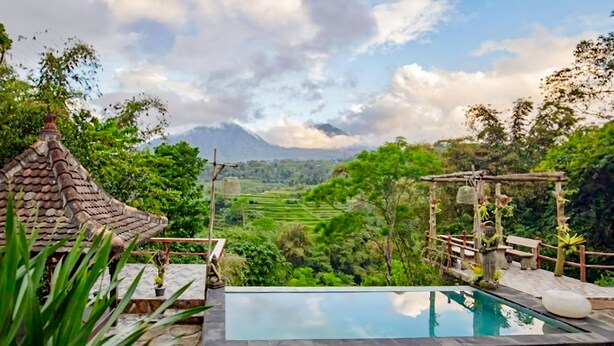 Una piscina con vistas a campos escalonados y montañas.