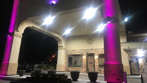 A building entrance with a brick facade, a star logo, and multiple lights. - Executive Inn Odessa (Odessa)