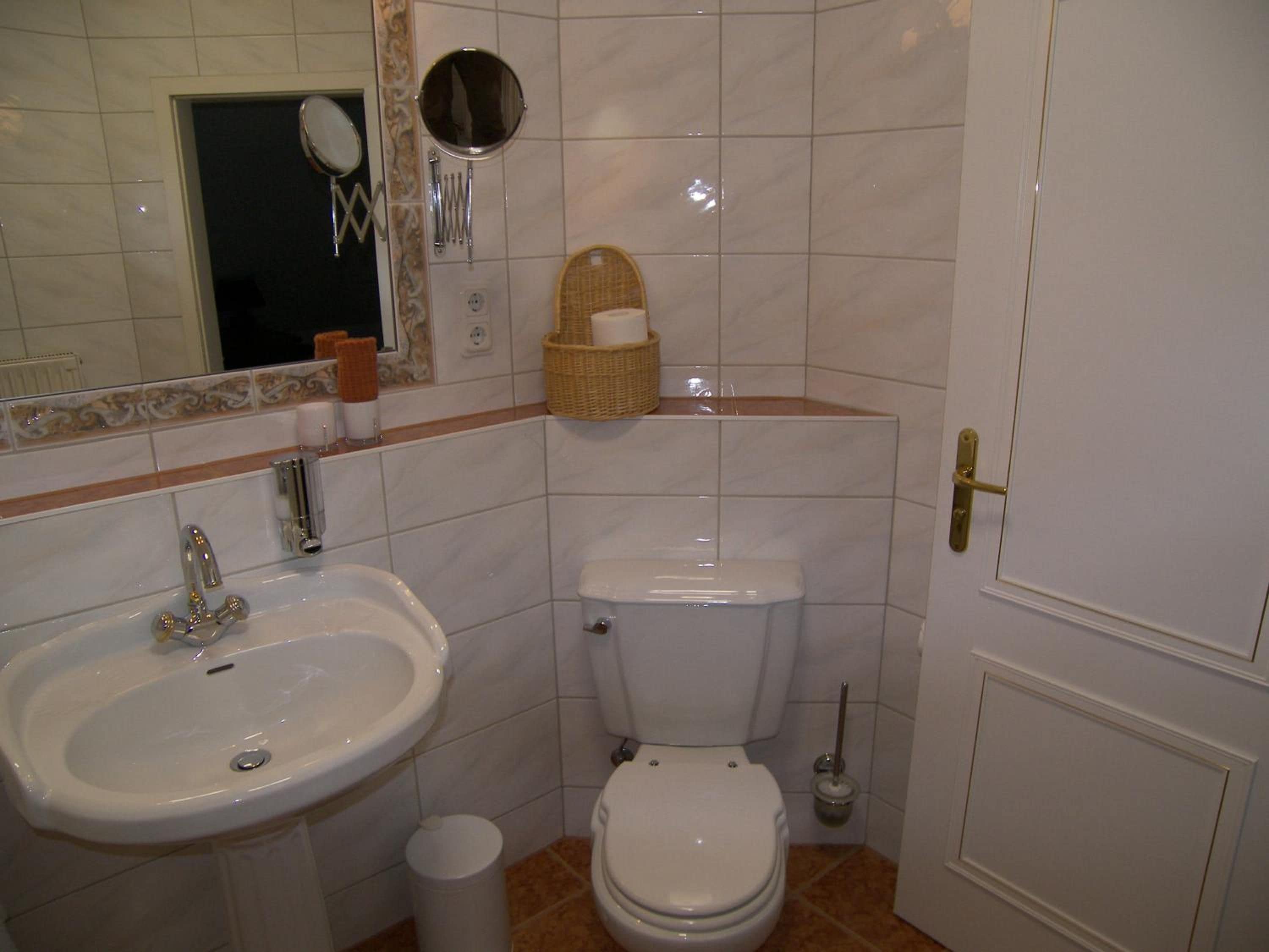 Ein Badezimmer mit Waschbecken, Toilette und Spiegel.