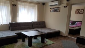 A modern living room with a sectional sofa, a small coffee table, and a wooden floor. - Haus Alpenblick Mölltal (Flattach)
