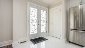 A clean, modern kitchen with white cabinetry and a stainless steel refrigerator. - Entire Bungalow 5 Bedrooms (Markham)