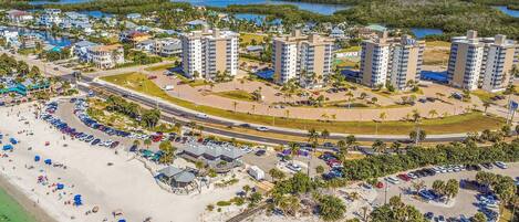 Ein Luftbild eines Küstenresorts mit Hochhäusern, einem Strand und einem Parkplatz.