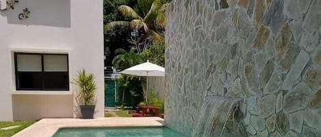 Piscine extérieure, parasols de plage, chaises longues
