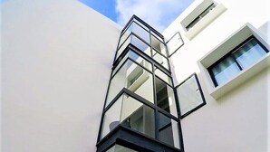 Un edificio moderno caratterizzato da un design angolare distintivo, con facciata in vetro e numerose finestre.