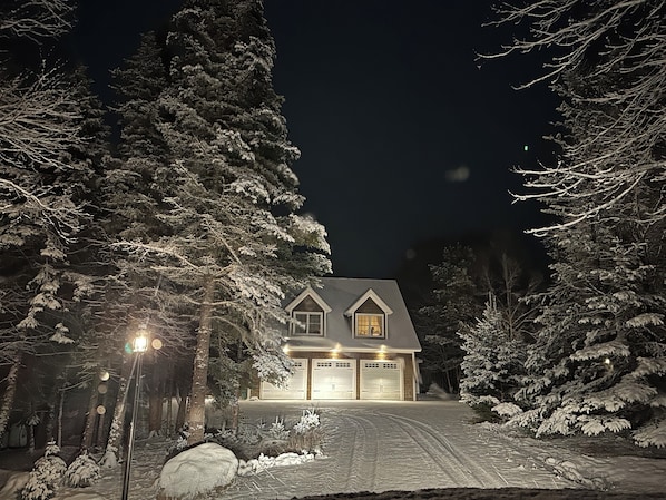 A house with a garage, surrounded by snow-covered trees. - Direct WATERFRONT, Acadia National Park, Mount Desert Island! (Tremont)