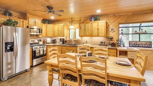A wooden cabin kitchen with a refrigerator, stove, microwave, and wooden cabinets. - 2 Mi to Rocky Mountain Nat'l Park: Cabin w/ Views (Grand Lake)