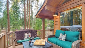 A wooden deck with a wicker sofa and a table set with food and drinks. - 2 Mi to Rocky Mountain Nat'l Park: Cabin w/ Views (Grand Lake)