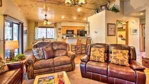 A spacious living room with leather sofas, a coffee table, and a ceiling fan. - 3 Mi to Fool Hollow Lake: Romantic Show Low Cabin (Show Low)