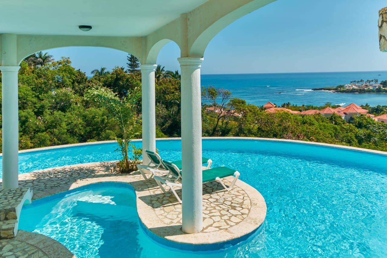 Une piscine offrant une vue sur l’océan et un paysage tropical.