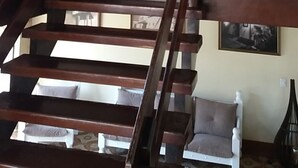 Eine Treppe mit hölzernen Geländern führt zu einer Sitzgelegenheit mit weißem Sofa.