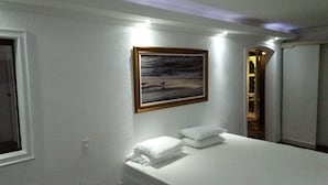 Ein Schlafzimmer mit einem Bett, einem Gemälde und einer Tür.
