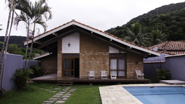 A house with a swimming pool, a patio with lounge chairs, and a brick exterior. - Comfortable beach house with pool, terrace, barbecue, 300 m from the beach. (São Sebastião)