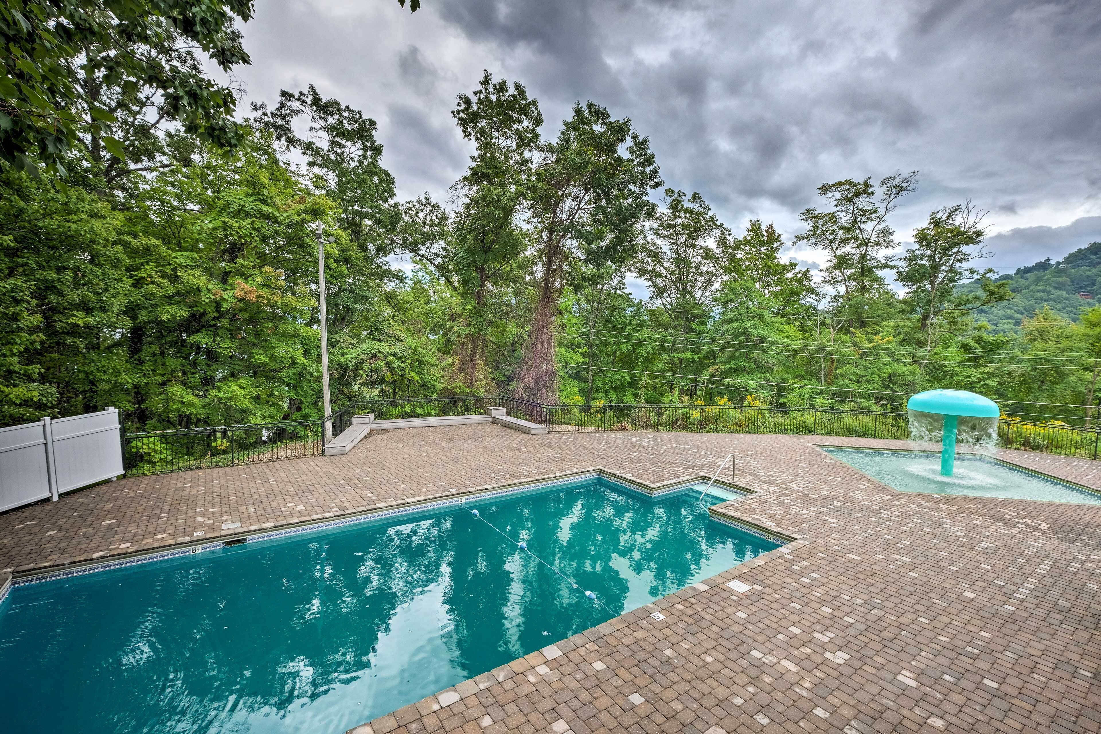 Une piscine entourée d’une terrasse en briques, bordée d’arbres et avec une chaîne de montagnes en toile de fond.