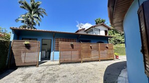 Un bâtiment à deux étages, à la façade bleue, avec une clôture en bois et une antenne parabolique.