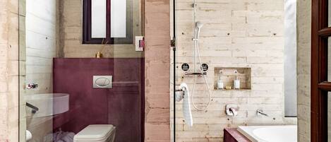 Un baño compacto con inodoro, ducha de vidrio y bañera.