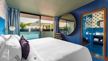 Camera d'hotel con un letto grande, vista sulla piscina e bagno con specchio e lavandino.