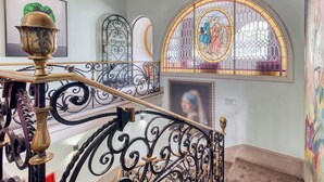 Een trap met sierlijke zwarte metalen leuningen en een decoratieve messing balustrade.