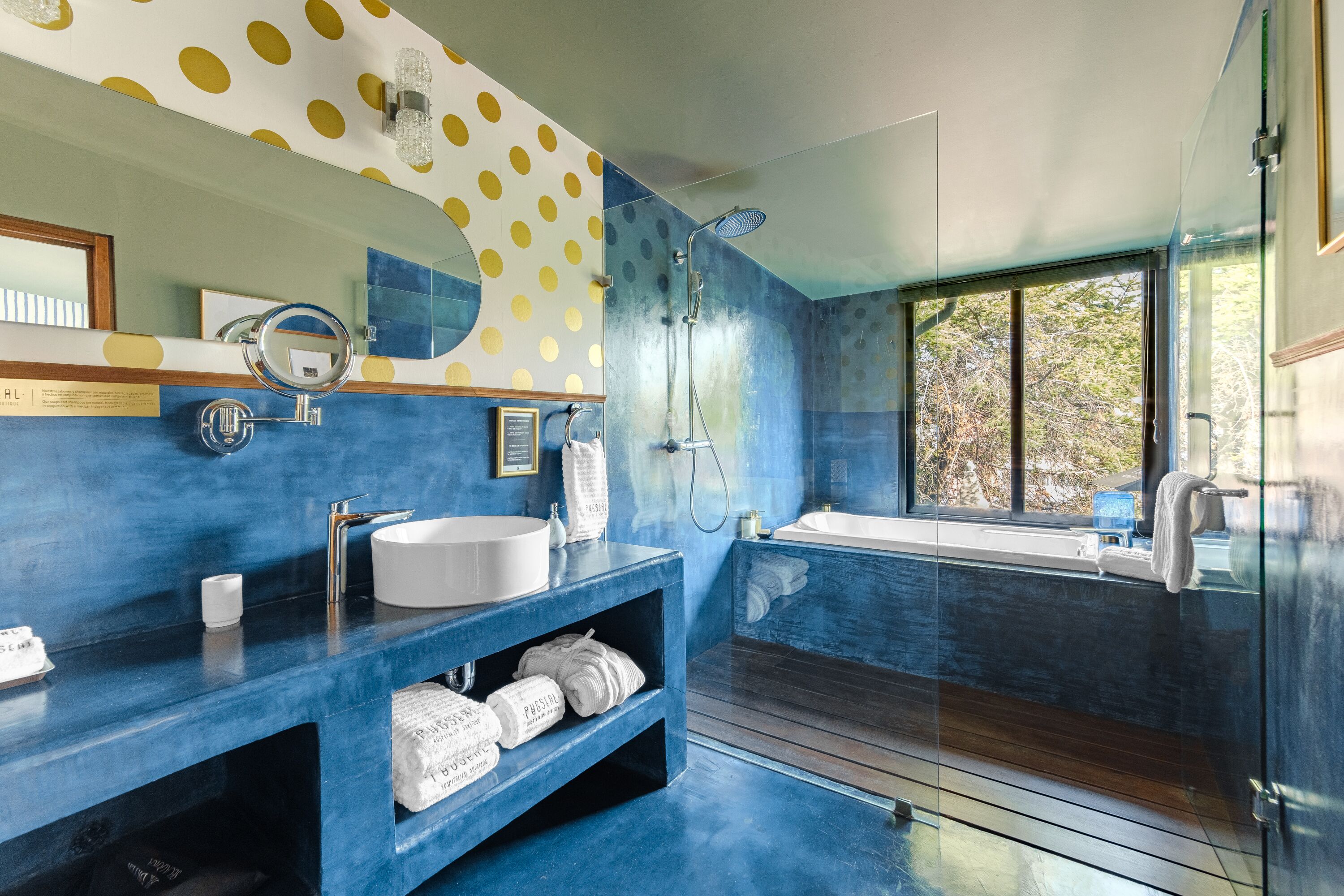 Une salle de bain moderne avec un grand miroir, un lavabo blanc, une baignoire et une douche.