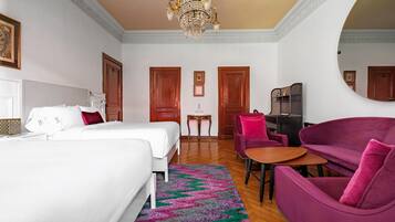 Una habitación de hotel con cama, escritorio, silla y sofá.