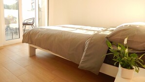 A bedroom with a bed, a potted plant, and a sliding glass door leading to an outdoor area. - Comfortable holiday house with apartments / Beautiful first floor apartment with terrace and grill / A3 (Pula)