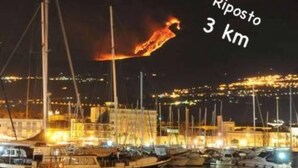 A marina at night with boats docked and a fire visible in the distance. - Typical house in finely furnished Sicilian style (Riposto)