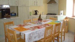 A kitchen with white cabinets, a stove, and a dining table with chairs. - House / Villa - LA BRESSE (La Bresse)