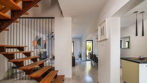 Ein modernes Interieur mit einer Holztreppe, einem Essbereich und einer Küche.